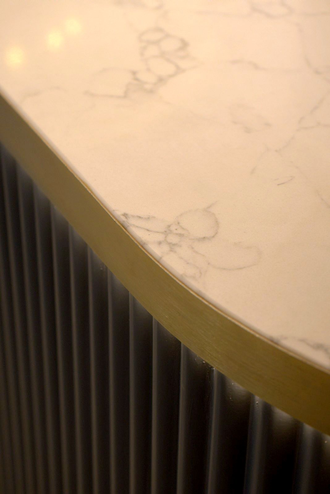 Curved stone counter top over timber half-rounds