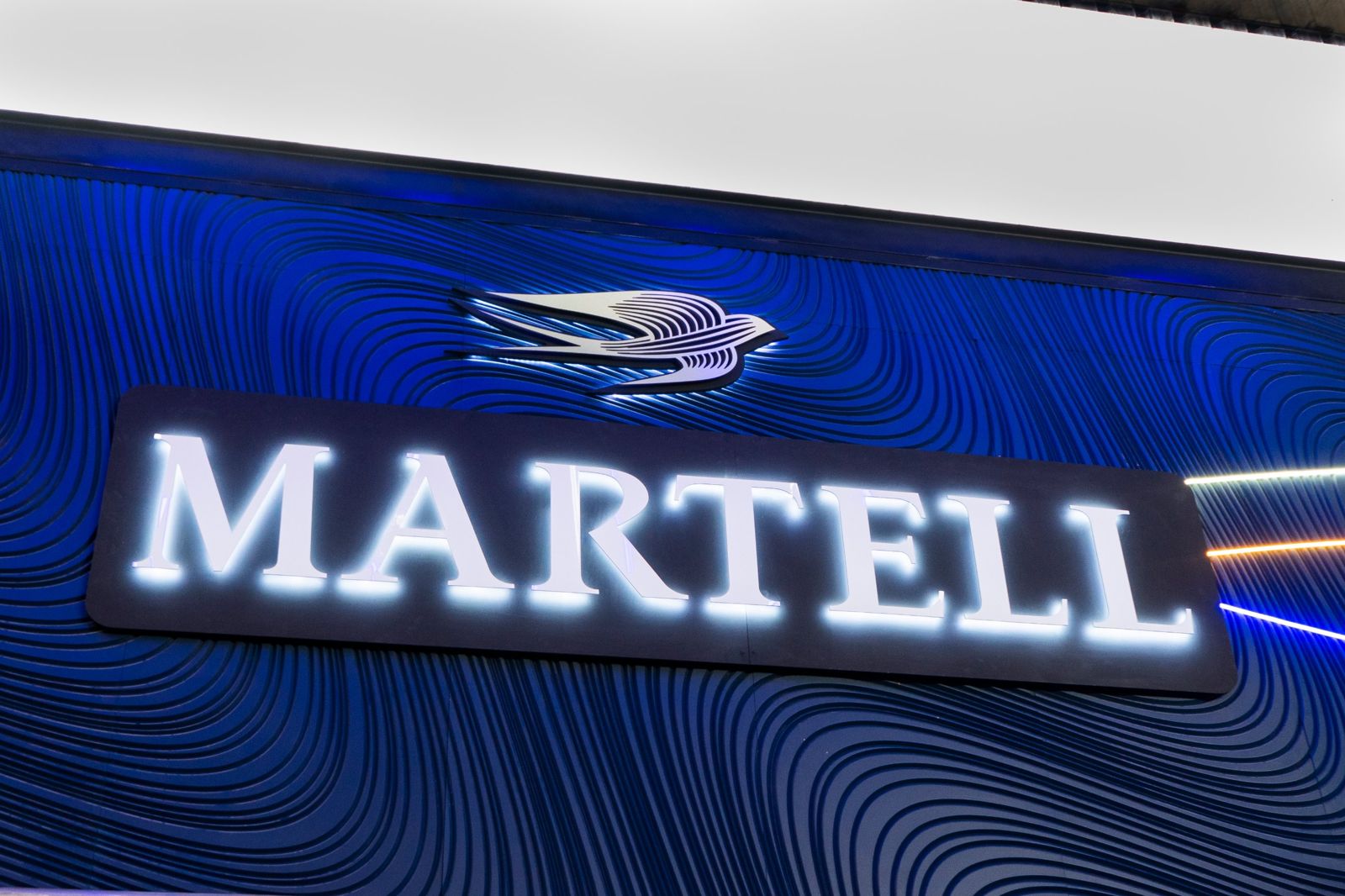Halo-lit Martell lettering on a CNC-routed wave wall